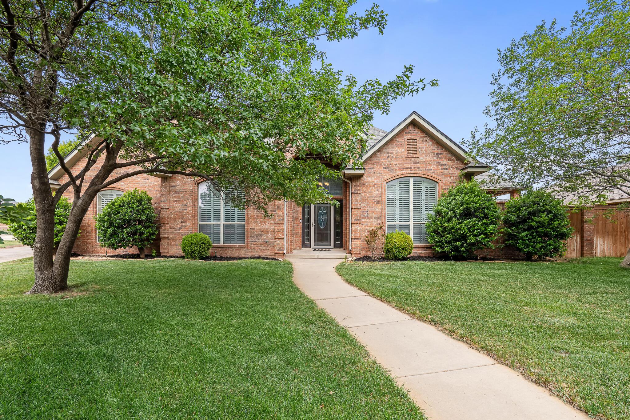 5008 Wesley Road Amarillo, TX 79119 - Photo 3 of 47 a front view of a house with a yard and trees