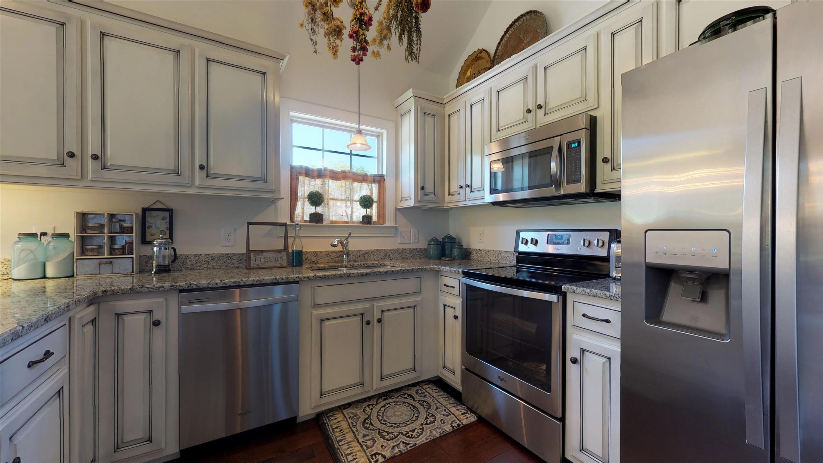 1065 Irish Way Spring Hill, TN 37174 - Photo 5 of 28 a kitchen with stainless steel appliances granite countertop a stove sink and cabinets