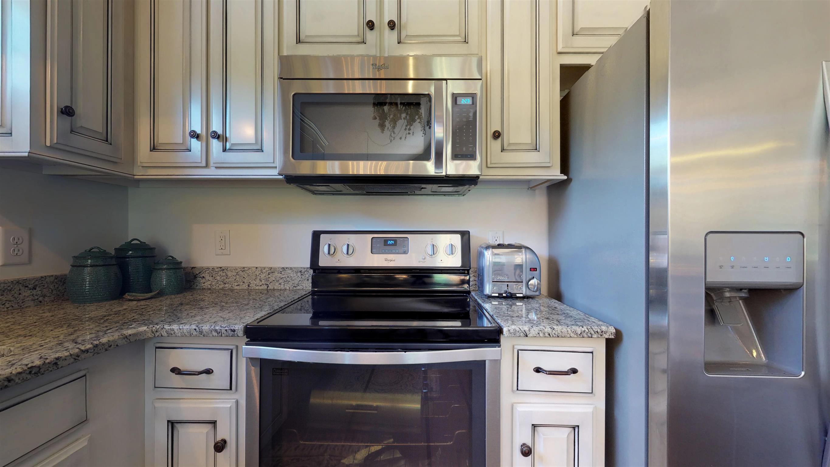 1065 Irish Way Spring Hill, TN 37174 - Photo 7 of 28 a kitchen with stainless steel appliances granite countertop a stove and a microwave