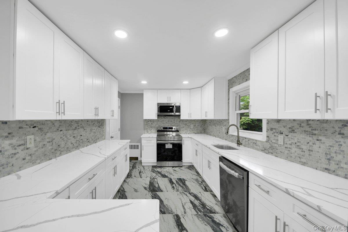 7 Rutledge Road Valhalla, NY 10595 - Photo 5 of 37 Modern kitchen featuring white shaker cabinetry, quartz countertops, a mosaic tile backsplash, stainless steel appliances, and large format marble-look floor tiles