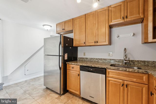 a kitchen with stainless steel appliances granite countertop a refrigerator sink and cabinets