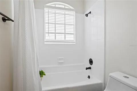 a bathroom with a bathtub a window and a shower