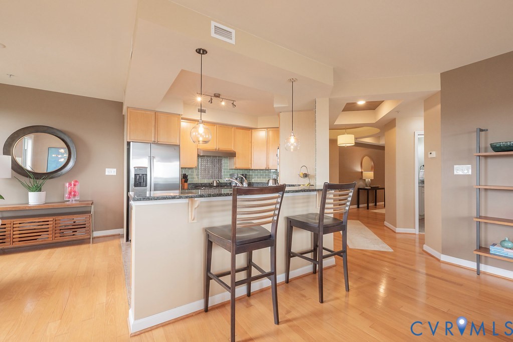 4820 Old Main Street, Unit 511 Henrico, VA 23231 - Photo 8 of 51 a kitchen with stainless steel appliances kitchen island granite countertop a table and chairs in it