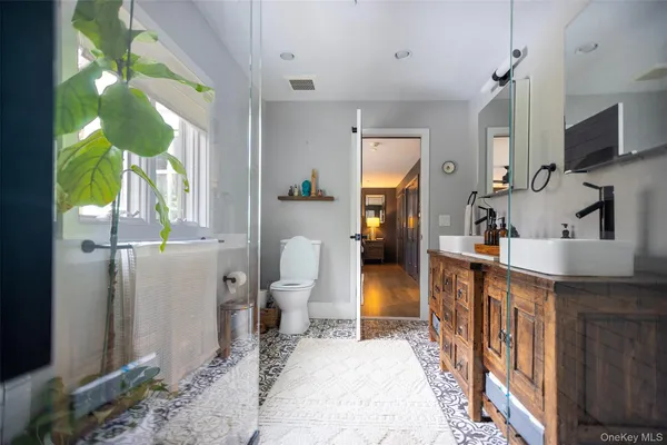 a bathroom with a granite countertop sink a toilet and a mirror