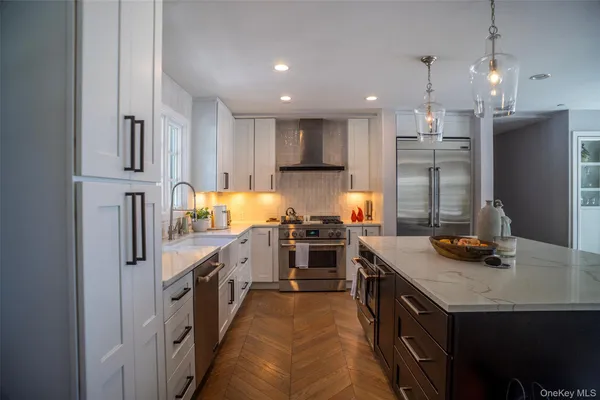 a kitchen with stainless steel appliances granite countertop a sink a stove and a refrigerator