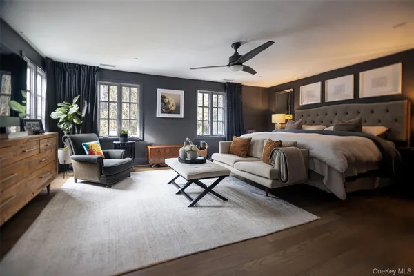 a spacious bedroom with a bed couch and a large window