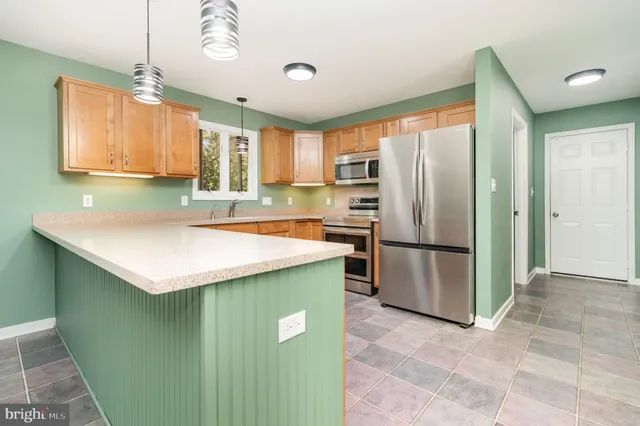a kitchen with a refrigerator a sink and a stove top oven