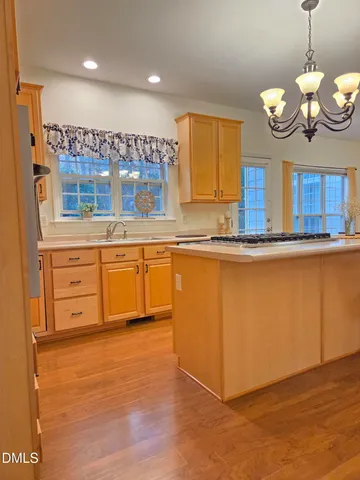 a large kitchen with stainless steel appliances granite countertop a sink and a wooden floors