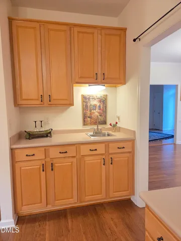 a kitchen with white cabinets and sink