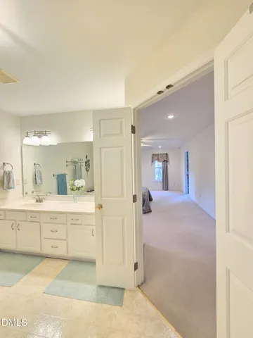 a large bathroom with a sink mirror and a bath tub