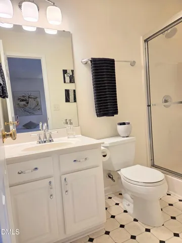a bathroom with a sink a toilet a shower and a mirror