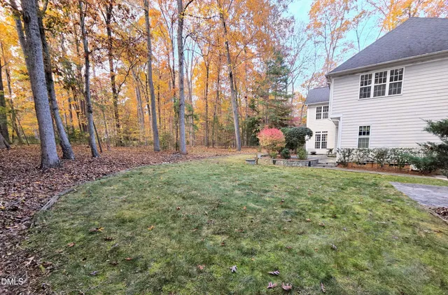 a view of a backyard with table and chairs and a large tree