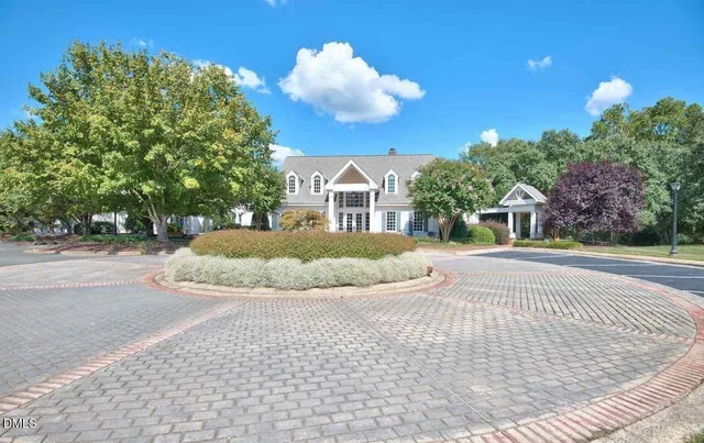a view of a white house with a yard and potted plants