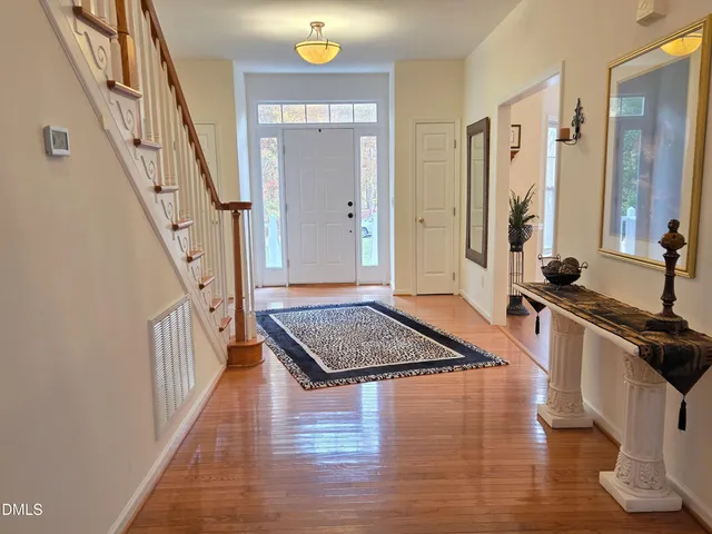 a view of a hallway with wooden floor and staircase