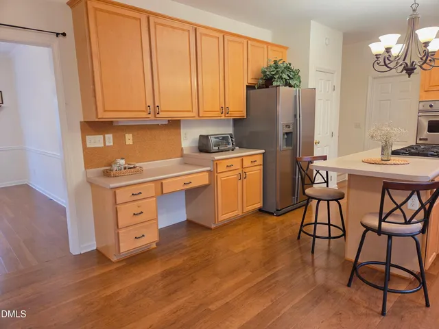 a kitchen with stainless steel appliances granite countertop a stove a refrigerator and a wooden cabinets