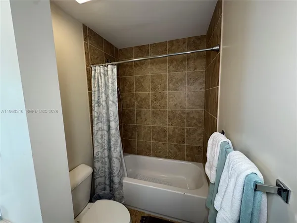 a bathroom with a shower curtain and a toilet