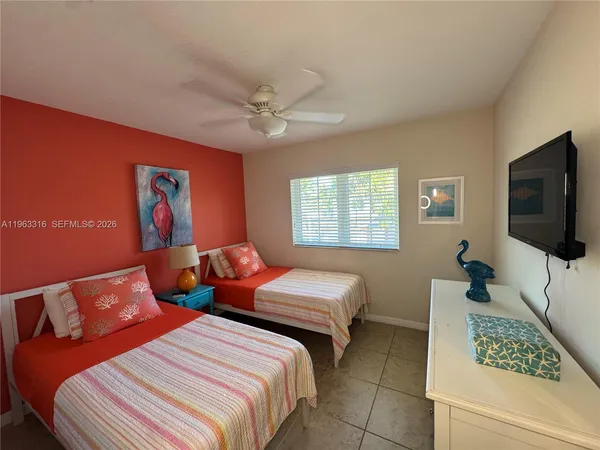a bedroom with two beds and a flat screen tv