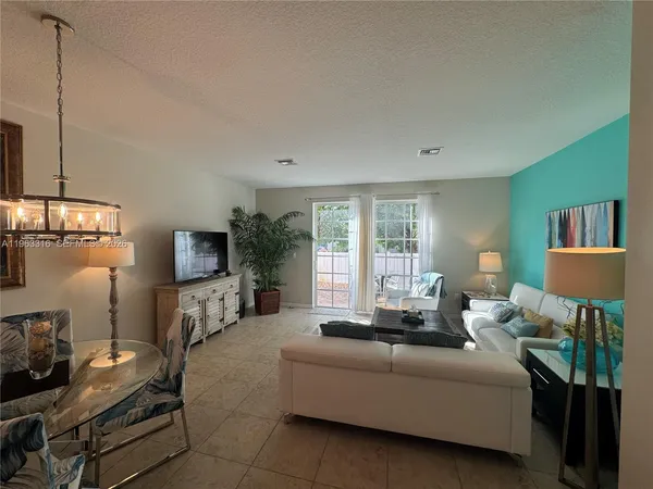 a living room with furniture a flat screen tv and a large window