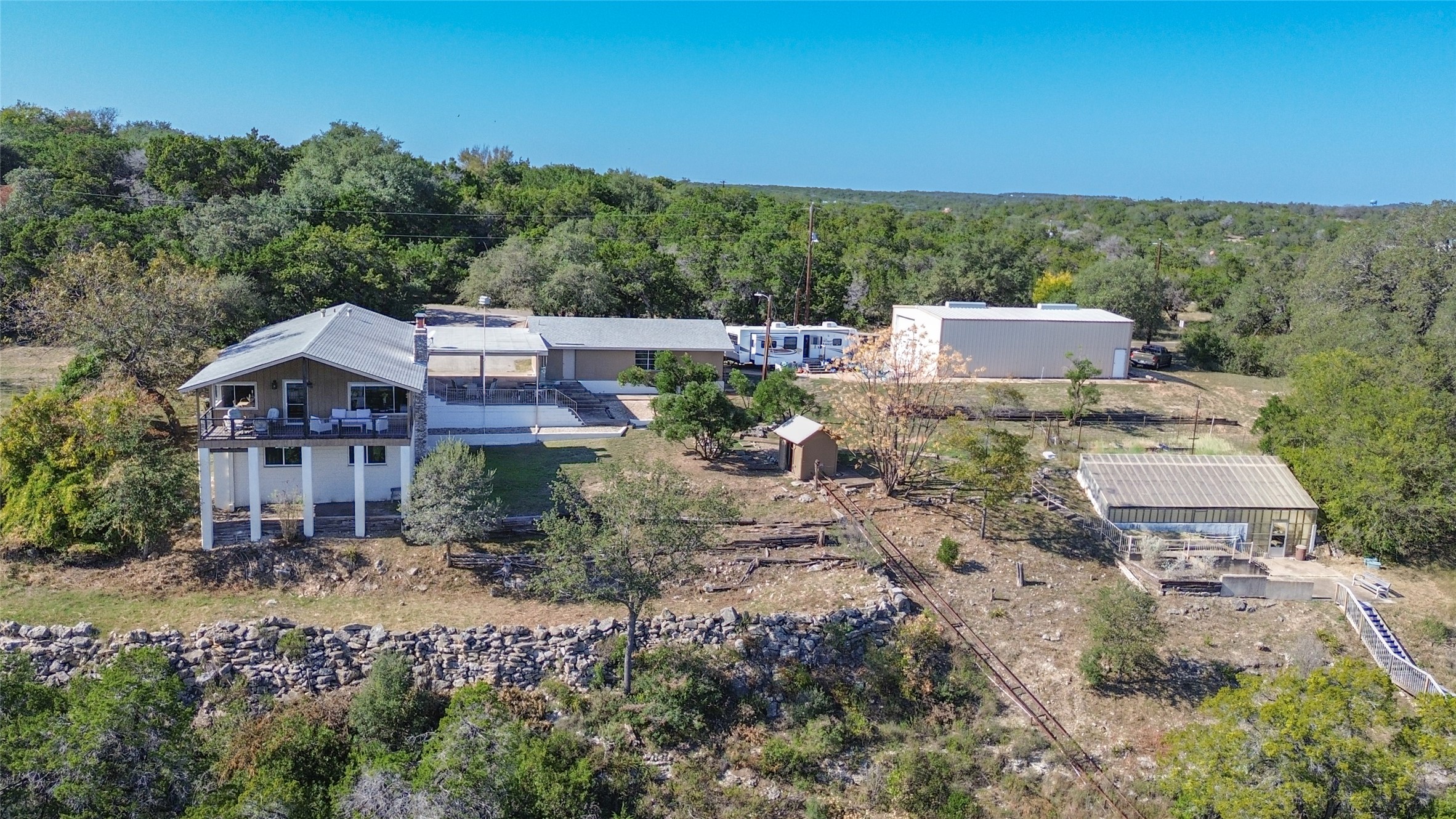 3807 Boat Dock Road Lago Vista, TX 78645 - Photo 1 of 37 Nestled among trees, this expansive property features multiple structures and verdant views.