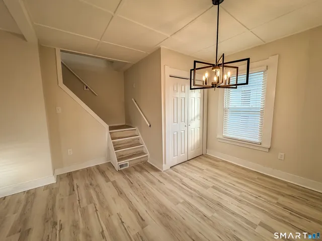 a view of a room with wooden floor and white walls