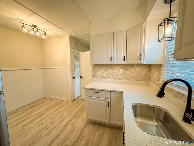 a kitchen with a sink cabinets and wooden floor