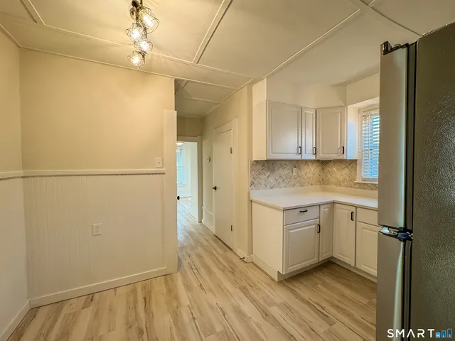 a kitchen with a refrigerator and a stove top oven