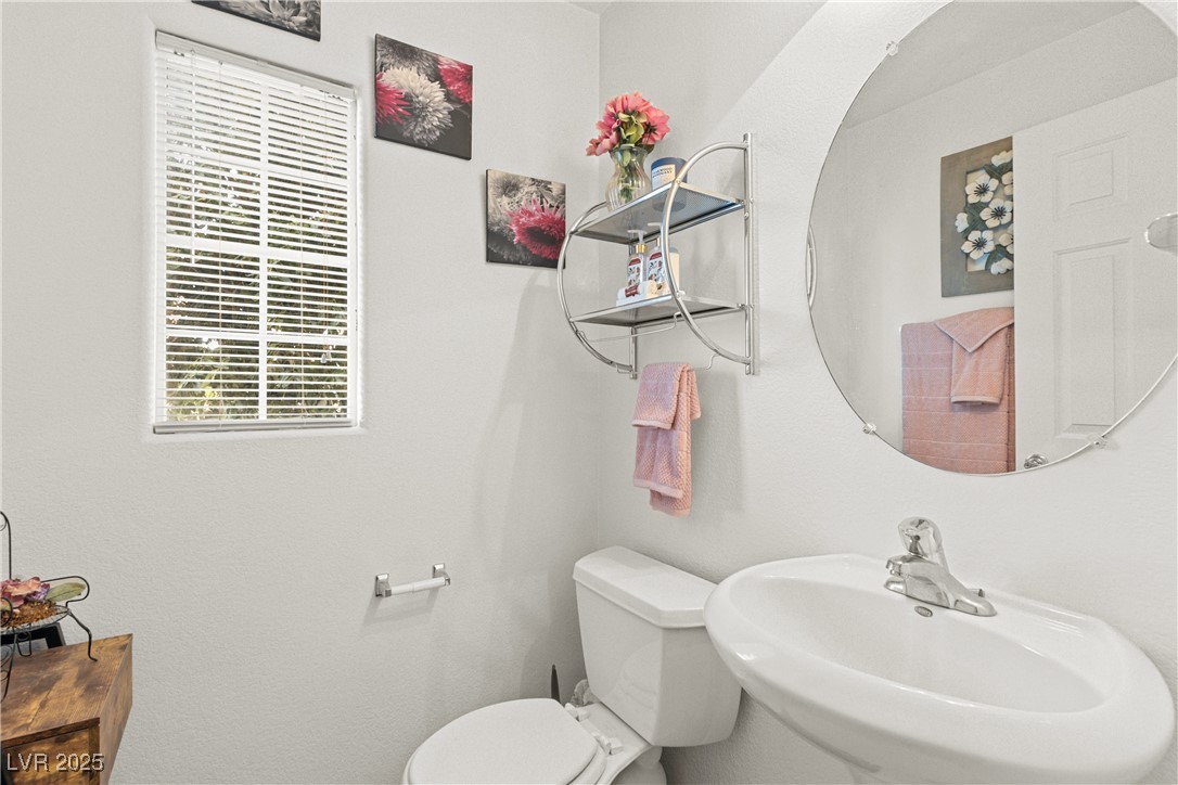 9105 Silk Threads Avenue Las Vegas, NV 89149 - Photo 11 of 25 Half bath featuring toilet and a sink