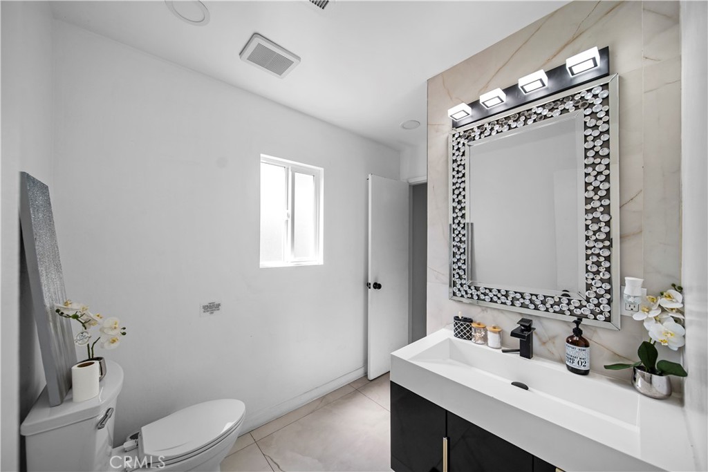 1158 North Ivescrest Avenue Covina, CA 91724 - Photo 20 of 27 a bathroom with a sink a toilet and mirror