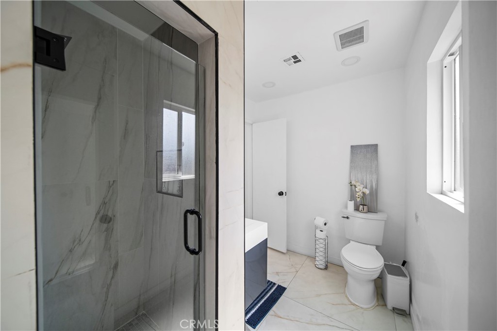 1158 North Ivescrest Avenue Covina, CA 91724 - Photo 21 of 27 a bathroom with a granite countertop toilet a sink and a mirror