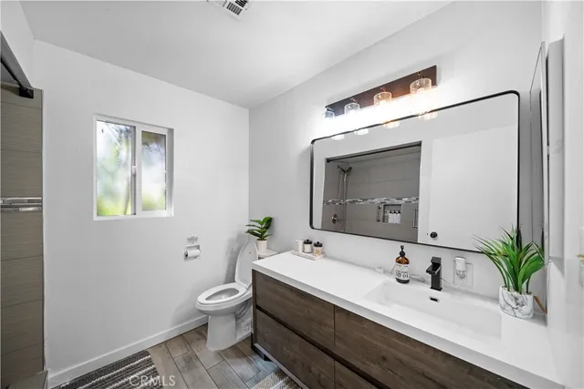 a bathroom with a toilet a sink and mirror