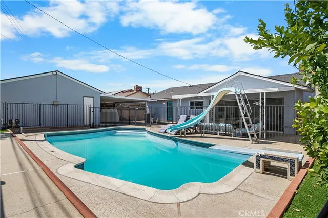 a view of a house with swimming pool and sitting area