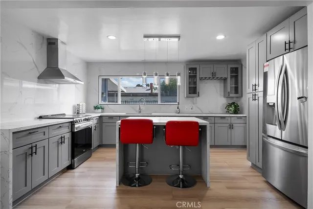 a kitchen with stainless steel appliances granite countertop a kitchen island hardwood floor sink stove and granite counter top