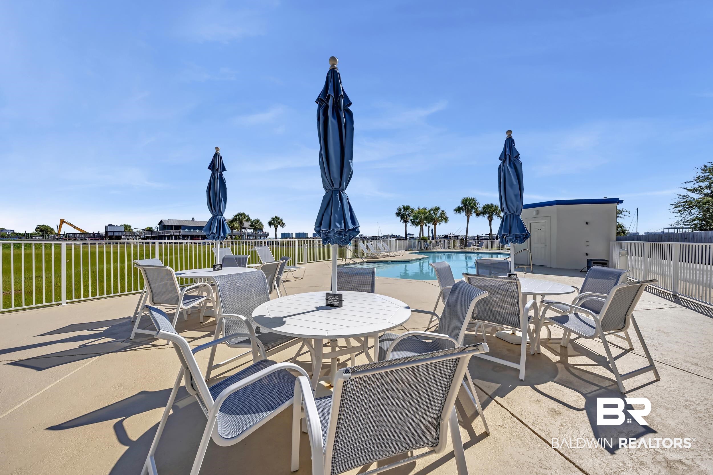 27282 Canal Road, Unit 104 Orange Beach, AL 36561 - Photo 60 of 79 View of patio / terrace featuring outdoor dining space, a community pool, and an outbuilding