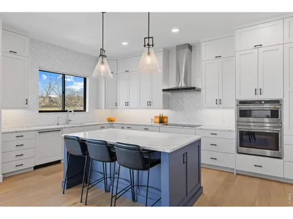 a kitchen with a stove a sink a center island and cabinets