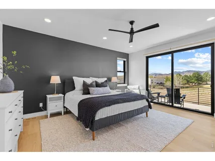 a bedroom with a large window and a balcony
