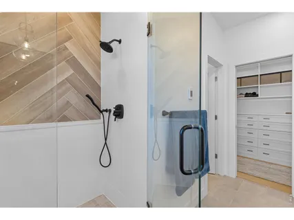 a view of walk in closet with clothes and shoes