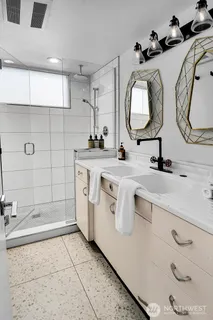 a bathroom with a sink a mirror and a shower