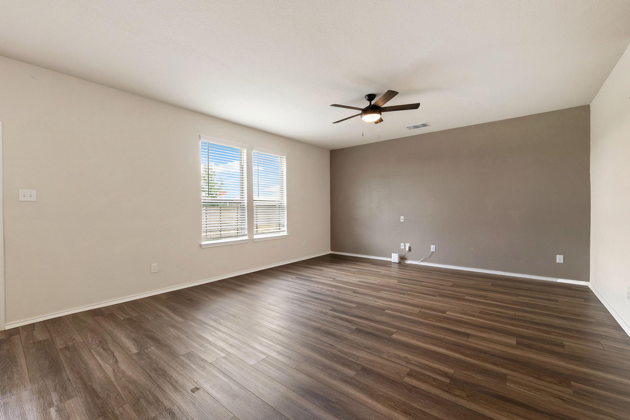 217 Innisfree Road Jarrell, TX 76537 - Photo 9 of 39 A well-lit living area features warm wood type flooring