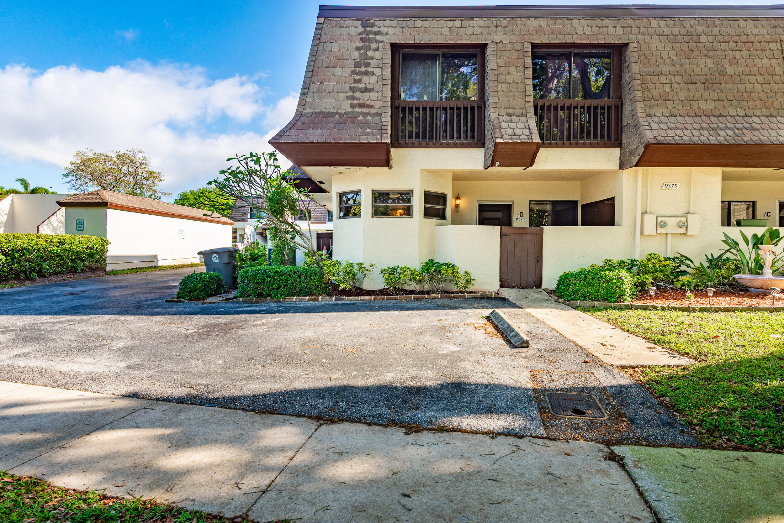 a view of a white building among the street with palm trees