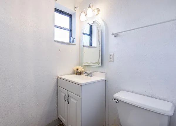 a bathroom with a toilet a sink a vanity and mirror