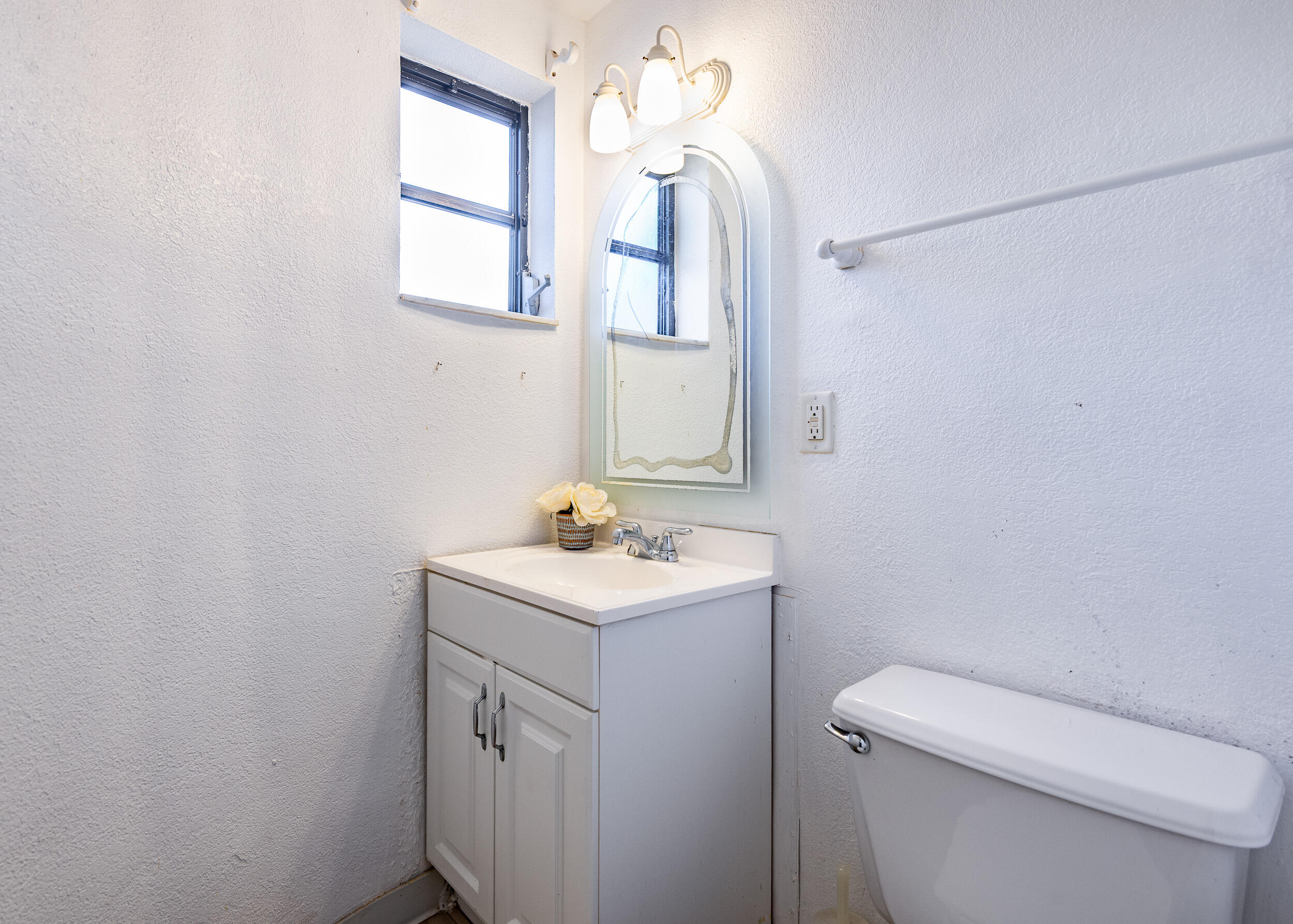 9375 Southwest 61st Way, Unit D Boca Raton, FL 33428 - Photo 14 of 30 a bathroom with a toilet a sink a vanity and mirror