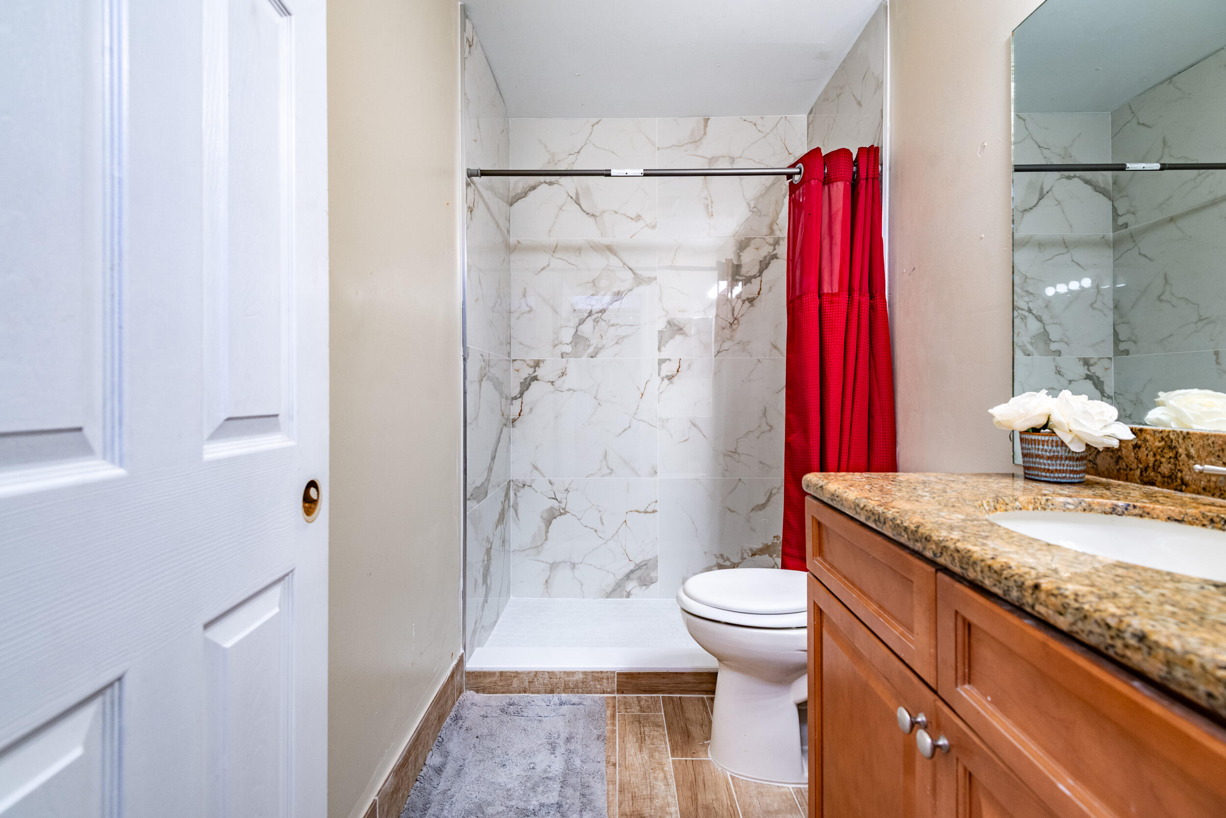 9375 Southwest 61st Way, Unit D Boca Raton, FL 33428 - Photo 17 of 30 a bathroom with a granite countertop sink a toilet and shower