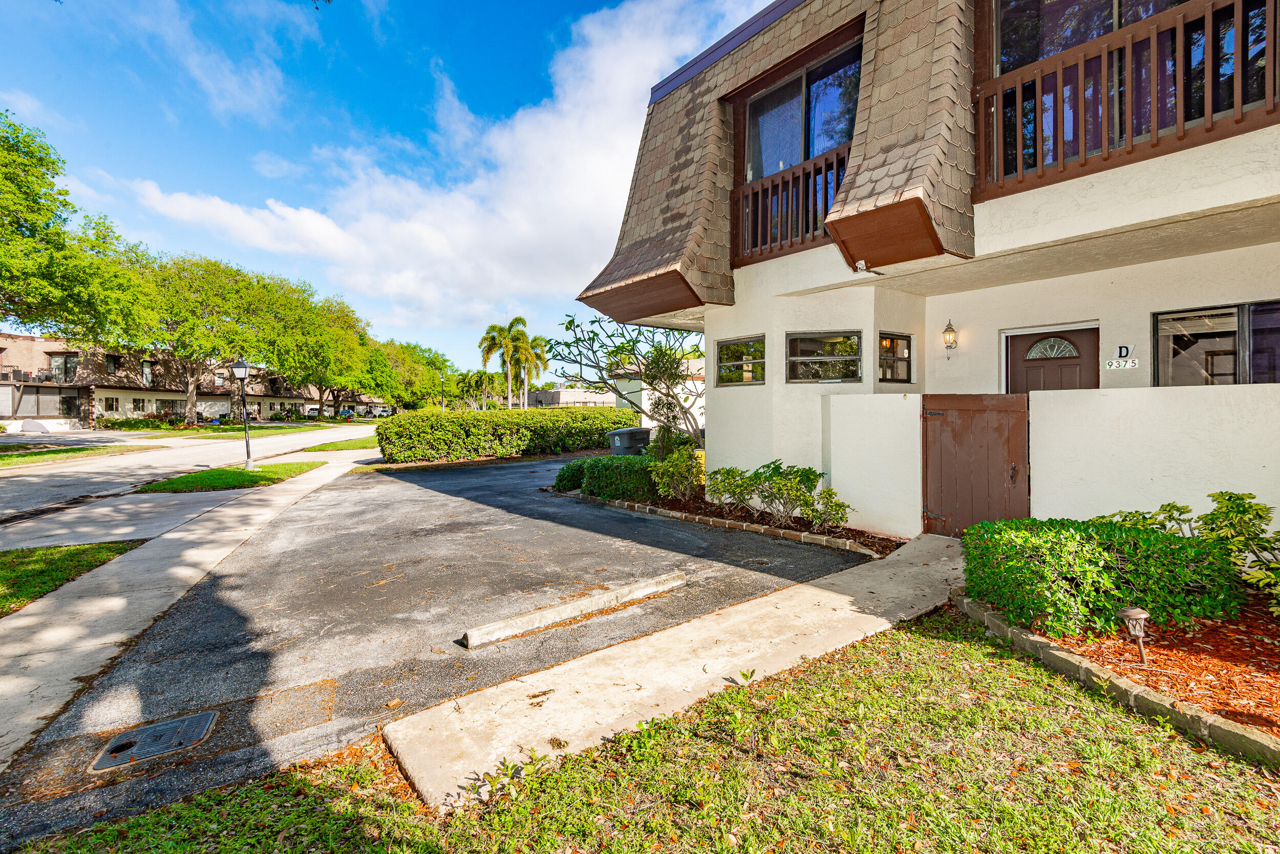 9375 Southwest 61st Way, Unit D Boca Raton, FL 33428 - Photo 26 of 30 a view of a house with a yard and potted plants