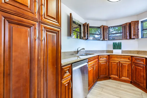 a kitchen with stainless steel appliances granite countertop cabinets and window
