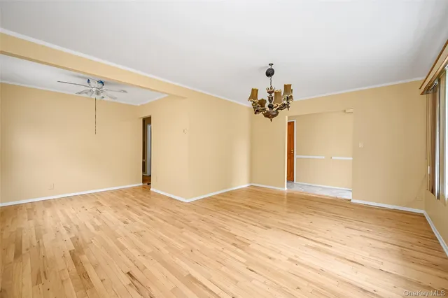 a view of a room with a wooden floor and chandelier