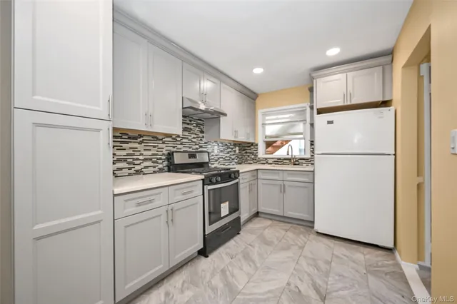 a kitchen with white cabinets and white appliances