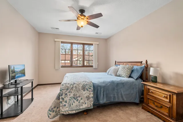 a bedroom with a bed a window and a flat screen television