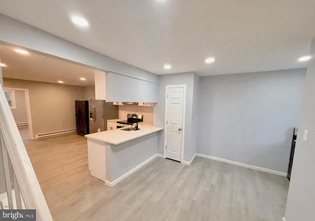 a kitchen with stainless steel appliances granite countertop a refrigerator oven a sink dishwasher and white cabinets with wooden floor