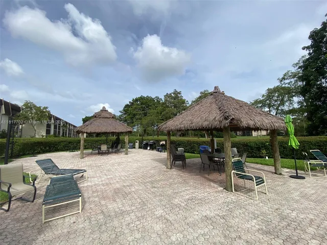a view of patio with a table and chairs under an umbrella