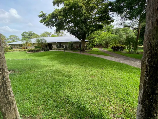 a view of a house with a backyard
